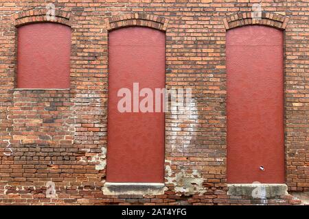 3 drei rote Fenster mit Backstein-Bauhof Stockfoto