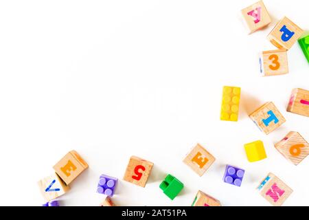 Buntes Babyspielzeug auf weißem Hintergrund. Rahmen aus der Entwicklung von Holzblöcken, Autos und Puzzles. Natürliches, umweltfreundliches Spielzeug für Kinder. Draufsicht. Flaches Lay. Kopierbereich. Stockfoto