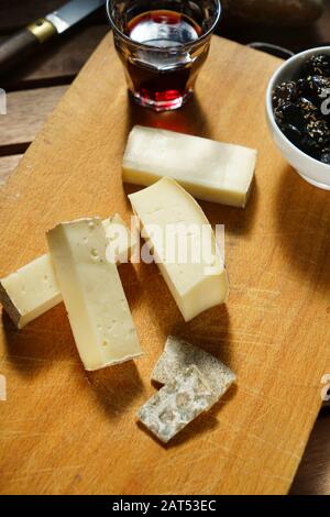 Gereifter sizilianischer Käse aus Castronovo, schwarze, gewürzte sizilianische Oliven und ein Glas Rotwein Syrah, Sizilien, Italien, Europa Stockfoto