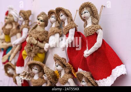 Hängende handgefertigte Marionettenmodelle von Menschen mit traditionellen Kostümen aus Jute zum Verkauf Stockfoto