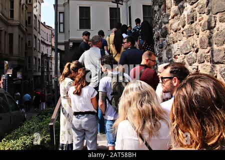 Istanbul, TÜRKEI - 16. September 2019: Touristen stehen vor dem Galata-Turm Schlange. Overtourismus-Konzeptbild. Stockfoto