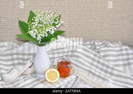 Stillleben ein Blumenstrauß aus weißen Lilienblättern des Tals in einer Glasvase. Stockfoto