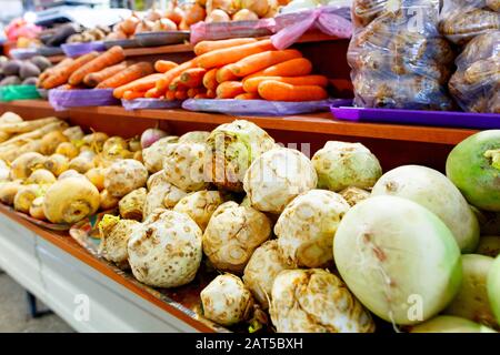 Sellerie, Rübe, Karotten, Zwiebeln, Wurzeln und anderes Gemüse werden in den Regalen des Marktes verkauft. Stockfoto
