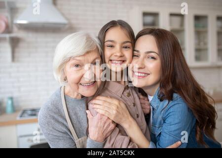 Schöne und glückliche Frau umarmte ihre Tochter und ihre Mutter Stockfoto