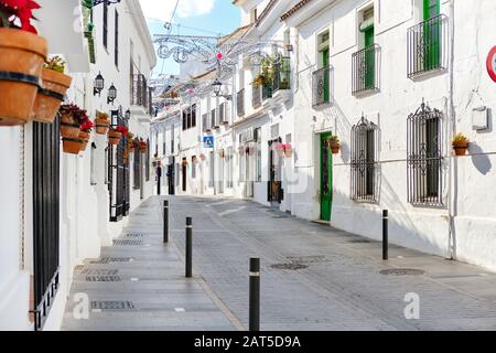 Mijas weiße Straße, kleines berühmtes Dorf in Spanien. Charmante, leere Gassen mit Neujahrsschmuck, Málaga, Spanien Stockfoto
