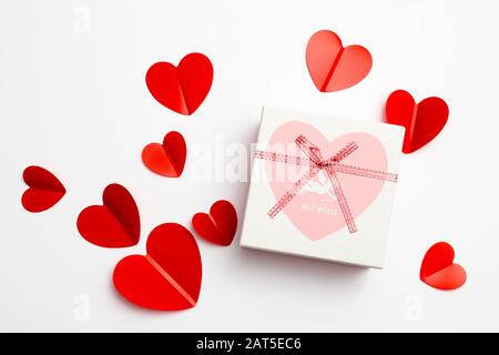 Grußkarte zum Valentinstag. Umschläge auf weißem Hintergrund und rote Kunststoffherzen. Kopierbereich. Stockfoto