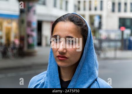 Schöne indische Frau mit blauer Kapuze, die den Kopf bedeckt. Blick weg von der Kamera. Nahaufnahme. Stockfoto