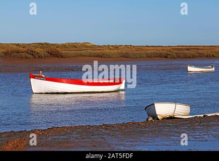 Drei kleine Boote im Hafen an der Norfolkküste bei Burnham Overy Staithe, Norfolk, England, Großbritannien, Europa. Stockfoto