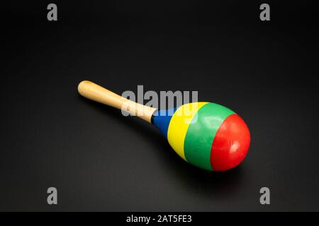 Nahaufnahme eines farbenfrohen Maracas, der auf einem schwarzen Untergrund liegt Stockfoto