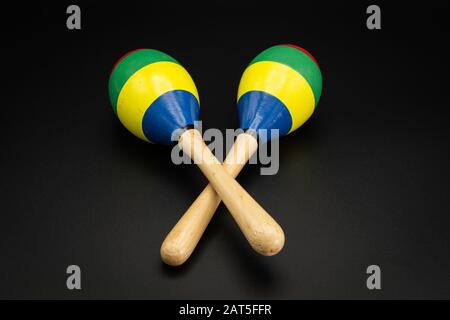 Nahaufnahme eines Paares bunter Maracas, das auf einem schwarzen Untergrund liegt Stockfoto