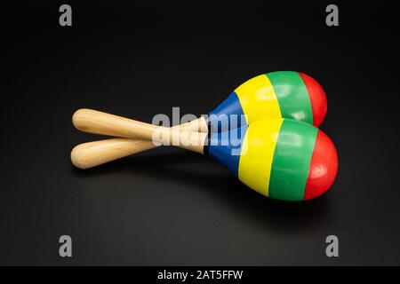 Nahaufnahme eines Paares bunter Maracas, das auf einem schwarzen Untergrund liegt Stockfoto