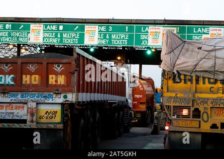 Fahrzeuge, Autos, LKWs warten an einer Mautstelle in Indien auf Barzahlung oder fastag-basierte Zahlung Stockfoto