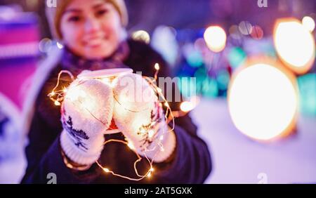 Mädchen hält Pappglas mit Kaffee oder heißem Tee im Winter in warmen Fäusten Stockfoto