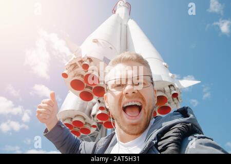 Fröhlicher Tourist, der selfie Foto über den Hintergrund des Raketenräumens, Konzept der kommerziellen Raumflüge, Mars Kolonisatoren macht Stockfoto