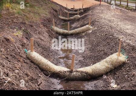 Landabflussarbeiten. Die Verwendung von Strohwatten. Stockfoto