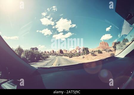 Beim Fahren gegen die Sonne, ein Vintage-Bild von einer Straße, die vom Vordersitz eines Autos aufgenommen wurde, ist ein Linsenflaum in den USA zu sehen. Stockfoto