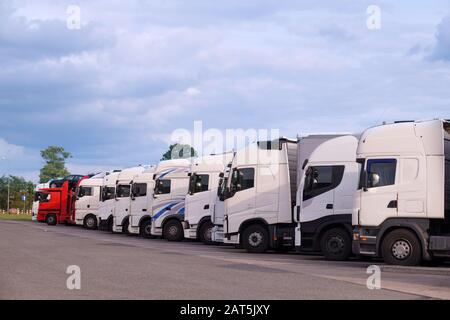 Rastplatz. Verschiedene Lkw-Typen auf dem Parkplatz neben der Autobahn. Stockfoto