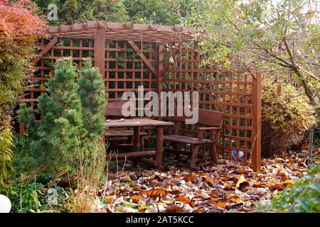 Pergola mit Tisch und Stühlen im Herbstgarten Stockfoto