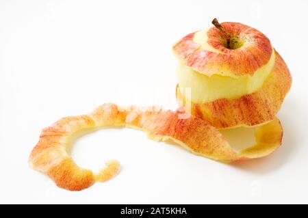 Apfel geschält mit verdrehter Haut auf weißem Tisch. Stockfoto