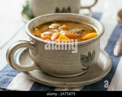 Hausgemachte Winterkürbis- und Bohnensuppe in einer Suppenschale. Stockfoto