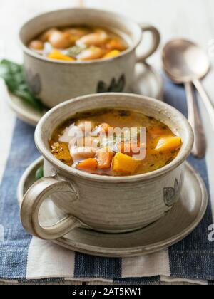 Hausgemachte Winterkürbis- und Bohnensuppe in einer Suppenschale. Stockfoto