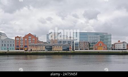 Alte Lagerhallen und moderne Bürogebäude am Kai des Flusses Liffey, Dublin an einem bewölkten Tag Stockfoto