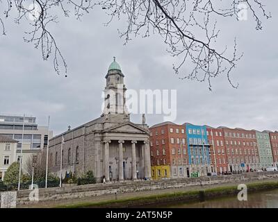 Die Kirche von Saint Paul in der griechischen Wiederauflebungsarchitektur, entworfen von Patrick Byrne, und die farbenfrohen Apartmentgebäude entlang des Flusses Liffey, Dublin Stockfoto