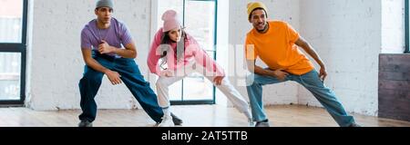 Panoramaaufnahme von modischen multikulturellen Männern und Frauen mit Breakdancing Stockfoto