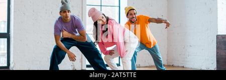 Panoramaaufnahme stilvoller multikultureller Tänzer in Hüten Breakdancing Stockfoto