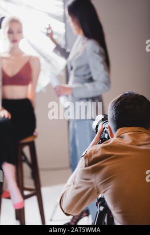 Selektiver Fokus des Fotografen, der Foto von Modell und Haarstylisten aufgenommen hat Stockfoto