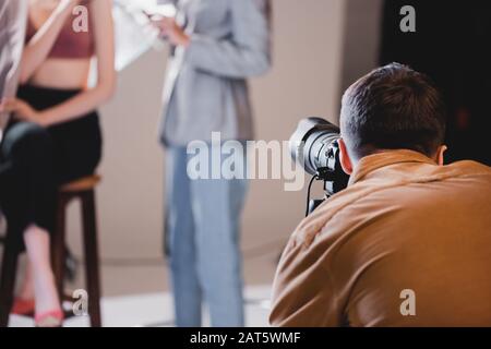 Selektiver Fokus des Fotografen, der Foto von Modell und Haarstylisten aufgenommen hat Stockfoto