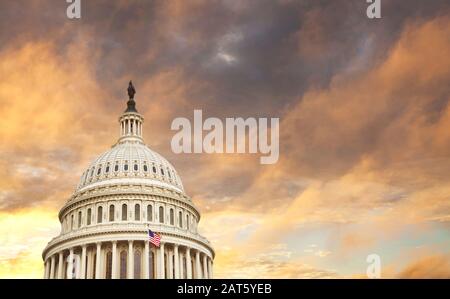 Die Kuppel des United States Capitol mit amerikanischer Flagge und dramatische Wolken hinter Stockfoto