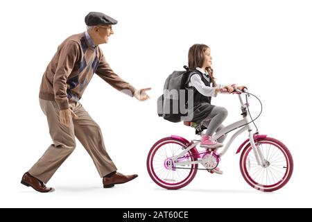 Lange Aufnahme eines Großvaters, der einem Mädchen beibringt, ein Fahrrad zu fahren, das auf weißem Hintergrund isoliert ist Stockfoto