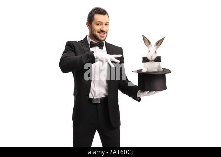Magier macht einen Zaubertrick mit einem Kaninchen in einem Hut, der auf weißem Hintergrund isoliert ist Stockfoto