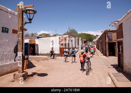 Touristen, die auf der Caracoles Street, San Pedro de Atacama, Antofagasta, Chile, spazieren gehen Stockfoto