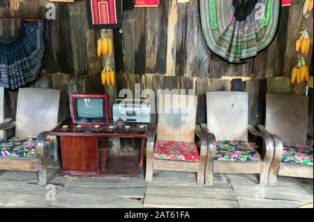 Retro-Wohnzimmer mit altem Fernseher, Tonbandgerät, Stühlen, Sesseln und Tisch. Wände aus Bretter, Fußboden aus Plank. Nostalgie. Nordvietnamesen Stockfoto