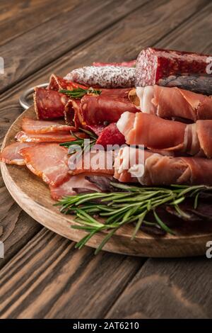 Köstliche Fleischplatte mit Rosmarin auf Holzbrett Stockfoto