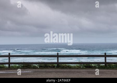 Kaaawa, Oahu, Hawaii, USA. - 11. Januar 2020: Azurblaue und weiße Brandung mit grauem Wasser in Richtung Horizont unter grauen Regenwolken vor Kaaawa o Stockfoto