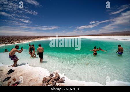 Touristen, die das salzige Wasser der Lagunas Escondidas de Baltinachi, Atacama-Wüste, Antofagasta, Chile, genießen Stockfoto