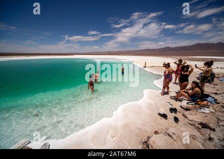 Touristen, die das salzige Wasser der Lagunas Escondidas de Baltinachi, Atacama-Wüste, Antofagasta, Chile, genießen Stockfoto