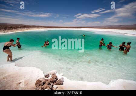 Touristen, die das salzige Wasser der Lagunas Escondidas de Baltinachi, Atacama-Wüste, Antofagasta, Chile, genießen Stockfoto