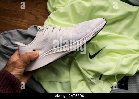 Paris Frankreich 23. September 2019 POV man Hand mit Blick auf die neuen weiBen professionellen Laufschuhe von Nike Zoom Rival Fly fur Frauen mit mehreren Profi Kleidungsstucken im Hintergrund Stockfo...