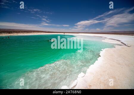 Touristen, die das salzige Wasser der Lagunas Escondidas de Baltinachi, Atacama-Wüste, Antofagasta, Chile, genießen Stockfoto