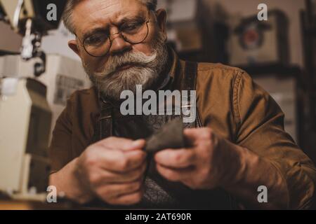 Selektive Fokussierung des aufmerksamen Kobblers auf echtes Lederstück Stockfoto