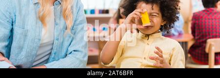 Panoramaaufnahme des Kindes, das vom Lehrer in der montessori-schule pädagogisches Spiel spielt Stockfoto