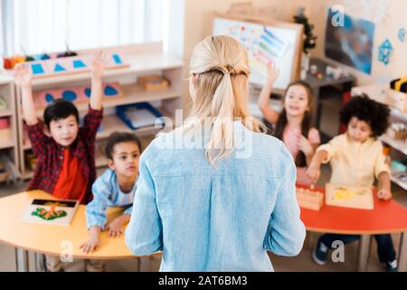 Selektiver Fokus der Lehrer, die mit Kindern in der montessori-schule Unterricht erteilen Stockfoto