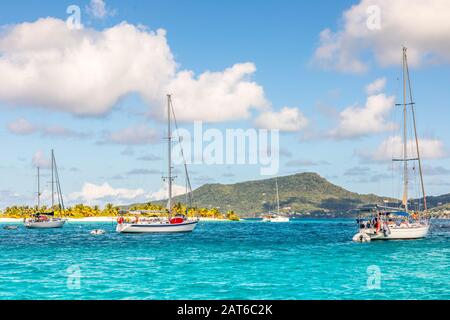 Türkisfarbenes Meer und vor Anker liegende Jachten auf Der Sandstrandinsel, in der Nähe der Insel Carriacou, der Insel Grenada, dem karibischen Meer Stockfoto