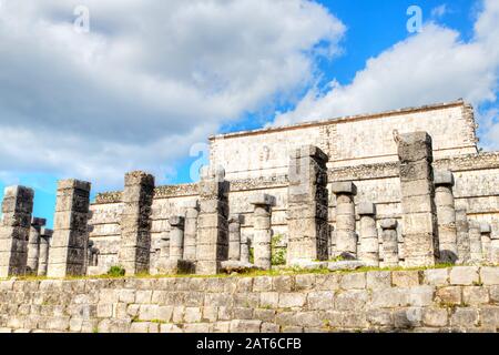 Die alten Maya-Ruinen in der nördlichen Kolonnade in Chichen Itza sind Teil der Thousand Columns Plaza. Die Säulen, die mit quadratischen Kapitellen bekrönt sind, erstrecken sich f Stockfoto