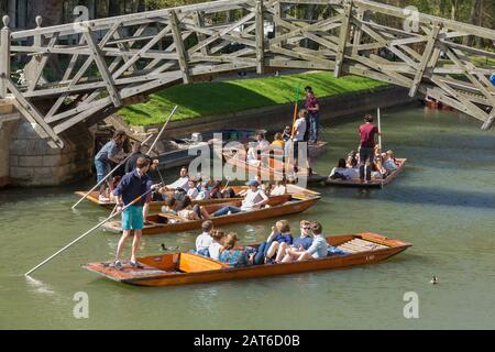 Touristen auf PUNTS auf der River Cam in Cambridge, Großbritannien, die unter der Mathematical Bridge vorbeiziehen Stockfoto