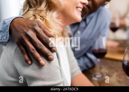 Beschnittenes Bild eines afroamerikanischen Mannes, der seinen lächelnden Freund umarmte Stockfoto